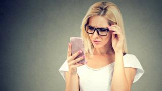 Mujer mirando un celular.