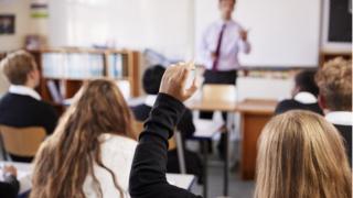 girl putting hand up in class