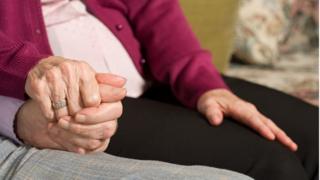 Elderly couple holding hands