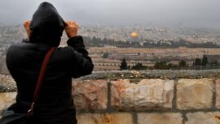 Человек смотрит на Старый город Иерусалима 6 декабря 2017 года