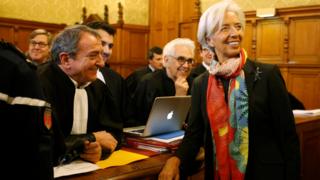 Christine Lagarde speaks with her lawyer Patrick Maisonneuve before the start of her trial about a state payout in 2008 to a French businessman, at the courts in Paris (12 December 2016)