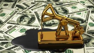 Maquinaria para extraer petróleo de juguete sobre un fondo de dólares