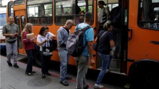 Un grupo de personas se montan en un autobús.
