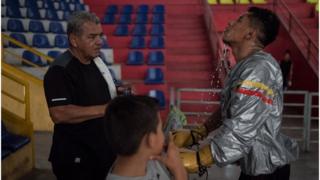 Boxer Ramiro Blanco throws water on his face during training