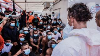 Migrants wearing masks onboard the Ocean Viking