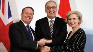 Liam Fox, Swiss Economic Minister Guy Parmelin and Liechtenstein's Minister for Foreign Affairs shaking hands