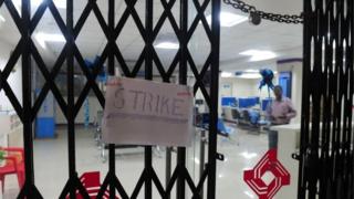 A "strike" placard is fixed onto the padlocked gate of a public sector bank during a nationwide strike called by 10 major trade unions over wages and economic reforms, in Chennai on September 2, 2016.