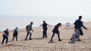 People head to a beach from the Border Patrol