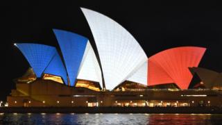 The iconic sails of the Sydney Opera House are lit in red, white and blue, resembling the colours of the French flag, in Sydney on November 14, 2015, as Australians express their solidarity