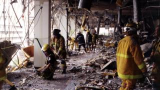 Firefighters work inside of building remains