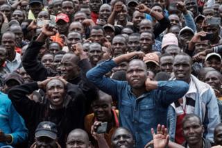 Hundreds of people in Eldoret watch Eliud Kipchoge's race against time on a screen.