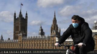 Man rides a bike outside the Houses of Parliament