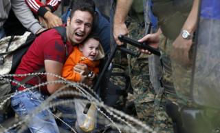 Мужчина и мальчик-мигрант были заблокированы македонской полицией возле Идомени, северная Греция, 21 августа 2015 года