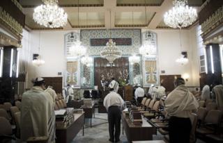 Iranian Jewish men wearing Tallit shawls and read from the Torah during morning prayers at Youssef Abad synagogue in Tehran on September 30, 2013. Present for more than 2,500 years in Persia, Iranian Jews have lost more than 70 percent of their 80,000 to 100,00 population who lived in Iran prior to the 1979 Islamic revolution, today Iran is home to some 8,750 Jews, according to a 2011 census. They are scattered across the country, but are mostly in the capital Tehran, Isfahan in the center, and Shiraz in the south. AFP PHOTO/BEHROUZ MEHRI (Photo credit should read BEHROUZ MEHRI/AFP/Getty Images)