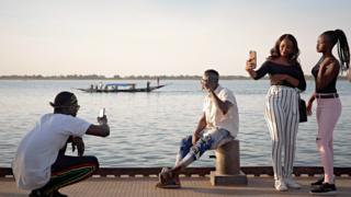 Malians take pictures of each other on the banks of River Niger in Segou, Senegal - Saturday 8 February 2020
