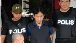 Ри Чон Чхоль в пуленепробиваемом жилете рядом с полицейскими, также носящими пуленепробиваемые жилеты, возле районного полицейского участка Сепанг в Сепанге, Малайзия Пятница, 3 марта 2017 года.