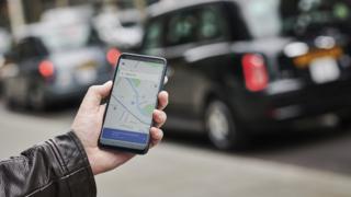 человек с открытым приложением Uber на своем смартфоне