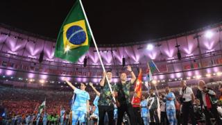 Бразильский призер 5-стороннего футбола Рикардиньо несет бразильский флаг на стадионе Маракан во время церемонии закрытия Паралимпийских игр 2016 года в Рио
