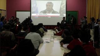 Indigenous people watch President Lenin Moreno and leaders of the indigenous movement on a television in the San Patricio Spirituality Centre in Quito, Ecuador, 13 October 2019