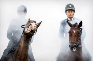 The Dutch Royal Guard guide their horses through clouds of thick smoke and gunfire on the beach of Scheveningen, near The Hague to prepare them for the Prinsjesdag parade. 16 September 2019
