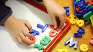 A child plays with magnetic letters