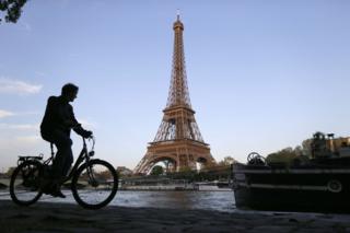 Cyclist on Seine towpath with the Eiffel tower in the background