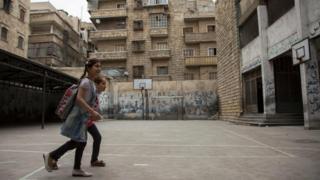 Girls arrive for school in the Shaar district of Aleppo, 7 May