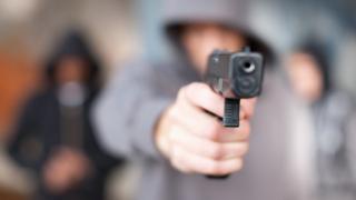 jóvenes apuntando con un arma