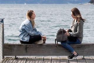 Women sit on the waterfront in Wellington on May 14, 2020.