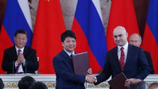 Chinese President Xi Jinping (L) and Russian President Vladimir Putin (R) applaud as Guo Ping (2L), Deputy Chairman of the Board and Rotating Chairman of Huawei, shakes hands with Alexei Kornya (2R), President and CEO of Russian mobile phone operator MTS, during a signing ceremony following Russian-Chinese talks at the Kremlin in Moscow on June 5, 2019.