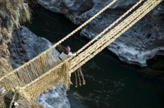 A man ties the ropes that form handrails