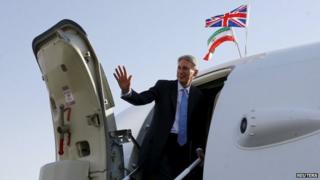 Britain's Foreign Secretary Philip Hammond waves as he boards a Royal Air Force aeroplane at Mehrabad Airport to leave Tehran