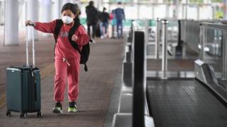 A girl wearing a facemask crosses from mainland China to Hong Kong. Photo: 8 February 2020