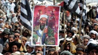 Manifestantes antiestadounidenses sostienen un cartel con la foto de Osama bin Laden, en Quetta, Pakistán, después de que fuera ultimado por fuerzas de EE.UU. en 2011
