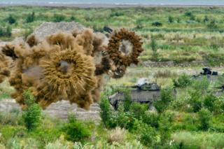 Armoured tanks launch smoke grenades