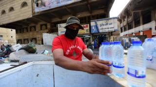 Ein Mann verkauft kaltes Wasser in Bagdad