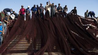 Fishermen arrange their nets.