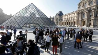 Los periodistas se paran frente al Louvre mientras se reabre al público por primera vez desde marzo