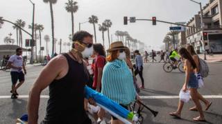 People crossing the street near a beach in California.