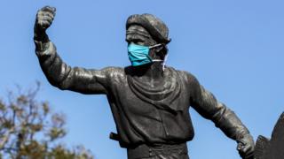 Estatua de gaucho en Montevideo con mascarilla.