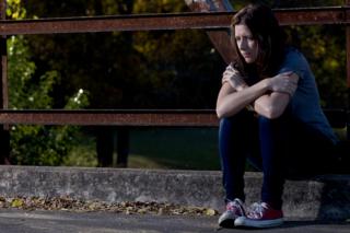 Woman sitting on a curb