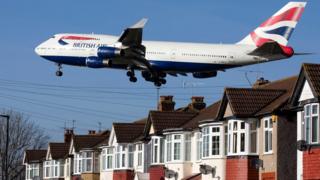 British Airways plane above houses