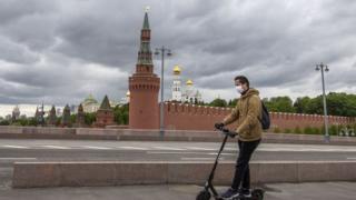 A man on a scooter wearing a face mask outside the Kremlin in Moscow