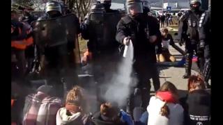 French riot police try to evacuate climate change activists blocking a road at Chambéry airport