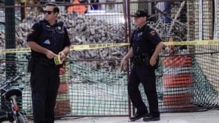 Kenosha police officers stand near a destroyed business