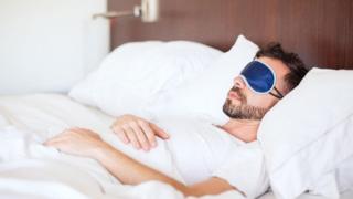 شاب ينام وهو يضع عصابة على عينيه