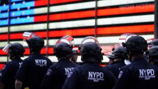 In this file photo taken on June 01, 2020 NYPD police officers watch demonstrators in Times Square on June 1, 2020, during a