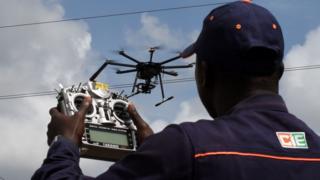 An employee of the Ivorian Electricity company (CIE) pilots a drone that ensures the monitoring of the hight voltage electric network, on July 10, 2017 in Bingerville, near Abidjan.
