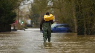 A man wades through floods in Upton upon Severn