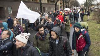Yürüyüşe katılanların barışın sembolü beyaz bayrak taşıyorlar